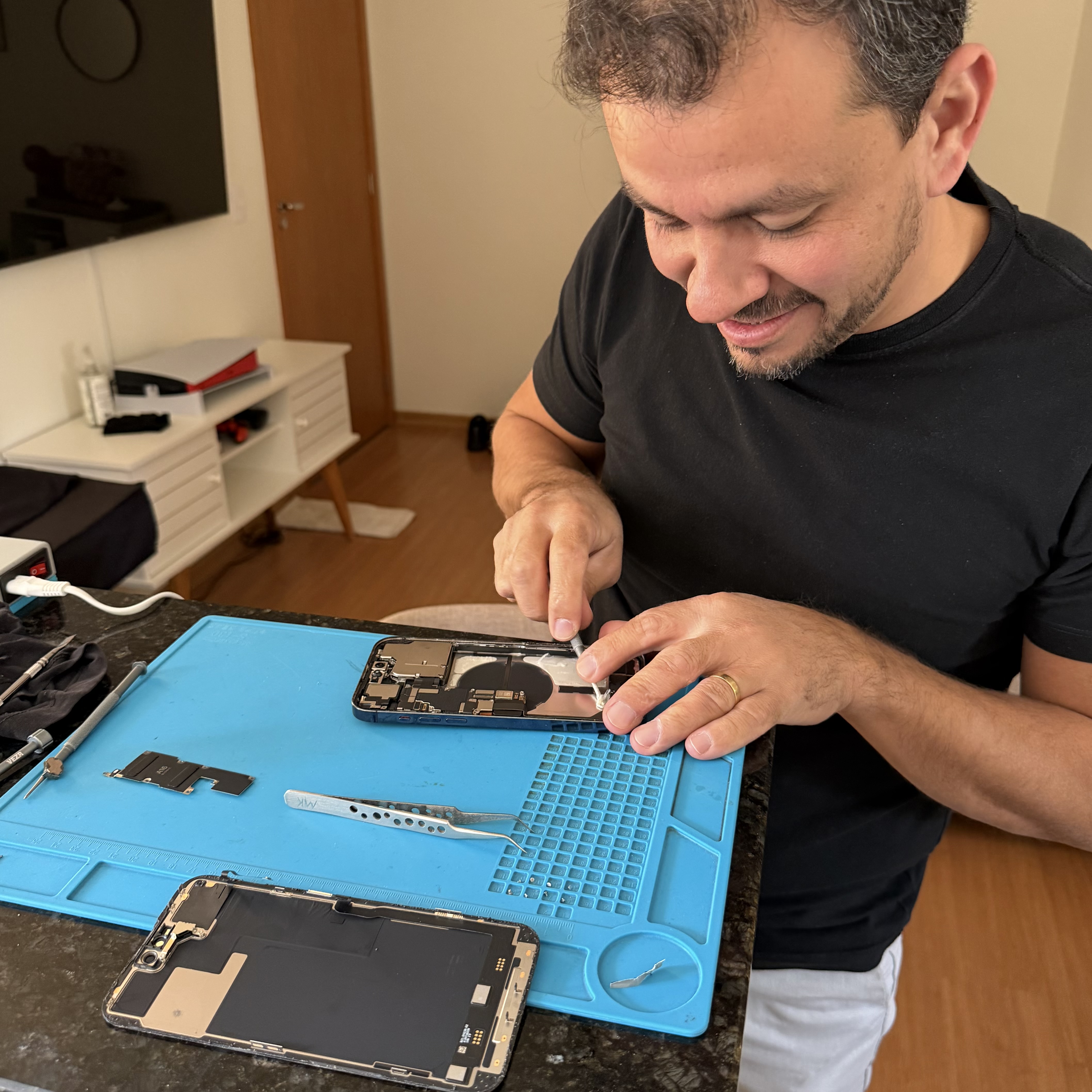Mikael Faustino realizando reparo de iPhone na casa do cliente